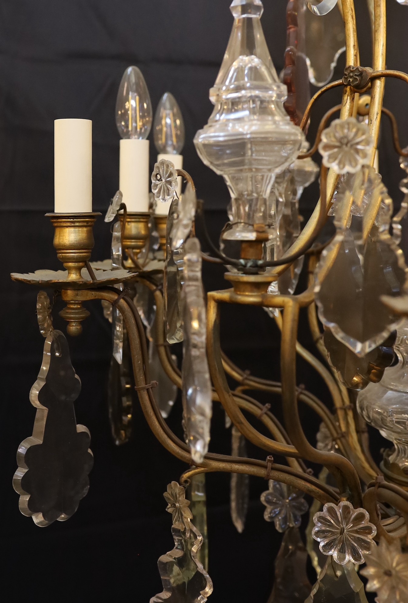 An early 20th century French gilt bronze and cut glass eight light chandelier profusely hung with lozenge and flowerhead drops, drop 110cm. width 65cm